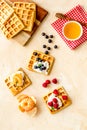 Beautiful yummy snacks. Waffles with cream and friuits on beige background top-down Royalty Free Stock Photo