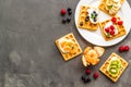 Beautiful yummy snacks. Waffles with cream and friuits on grey background top-down frame copy space Royalty Free Stock Photo