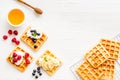 Beautiful yummy snacks. Waffles with cream and friuits on white background top-down frame copy space Royalty Free Stock Photo