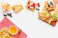 Beautiful yummy snacks. Waffles with cream and friuits on white background top-down frame copy space Royalty Free Stock Photo
