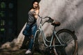 Beautiful yuong female in denim standing with bicycle Royalty Free Stock Photo