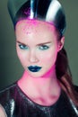 Beautifulgirl with creative cold pink makeup and glossy crown on a green