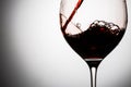 In beautifull glass poured red wine with waves and splashes Royalty Free Stock Photo