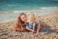 Beautifull mother lady with cute daughter girl on a beach sea side stylush dressed