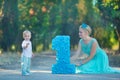 Beautifull mother lady mom in stylish blue dress together with her son and number one birthday in park