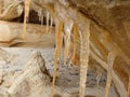 Picture with icicles on sandstone wall, blurred background