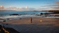 Beautifull sunrise at Salthill beach in Galway city, Ireland with lonely man and his dog
