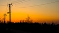 Beautifull yellow summer sunset sunset against the background village , building , trees and electricity power lines Royalty Free Stock Photo