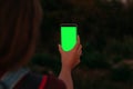 Beautifull young girls hand holding smartphone with blank screen. Green screen