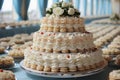 A beautifully arranged dessert table with lots of cream cakes on plates, sweets