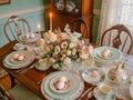 A beautifully arranged dining room table, set with flowers, fine china, and Easter decorations, ready for a delicious Royalty Free Stock Photo