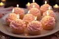 A beautifully arranged lit candles shaped like light pink cakes on a plate in a cozy living room