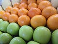 Beautifully arranged piles of oranges and apples