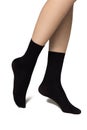 Beautifully cared feminine legs in a black short nylon socks Royalty Free Stock Photo