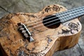 Wooden ukulele with floral pattern carving lying on rustic tabletop Royalty Free Stock Photo