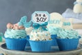 Beautifully decorated baby shower cupcakes for boy with cream on tray, closeup view