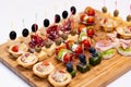 Beautifully decorated catering banquet table with different food snacks and appetizers with sandwich, caviar, fresh fruits on