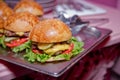 Beautifully decorated catering banquet table with different hamburgers burgers sandwiches on a plate on corporate birthday . Mini Royalty Free Stock Photo