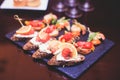 Beautifully decorated catering banquet table with different food snacks and appetizers with sandwich, caviar, fresh fruits