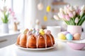 Beautifully decorated Easter bundt cake with white frosting and pastel colored sugar eggs. Glazed donut cake for Easter