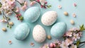 A beautifully decorated Easter egg arrangement with flowers on a pastel blue background Royalty Free Stock Photo