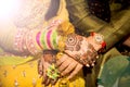 Beautifully decorated Indian bride hands with the groom.