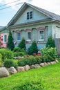 Russia, Uglich, July 2020. A small green garden in front of the facade of an old Russian wooden house. Royalty Free Stock Photo