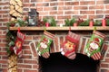 Beautifully decorated Santa Christmas socks hanging on a fireplace in brick wall waiting for presents, close-up view Royalty Free Stock Photo