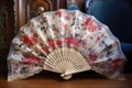 beautifully decorated spanish hand fan on lace fabric