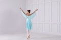 Beautifully dressed little ballerina dancing in studio