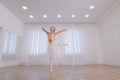 Beautifully dressed little ballerina dancing in studio