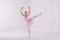 Beautifully dressed little ballerina dancing in studio