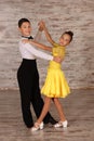 Beautifully dressed couple of kids dancing together in studio