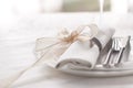 Beautifully elegant decorated table for holiday - wedding or valentine day with modern cutlery, bow, glass, candle and gift