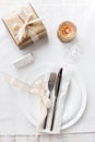 Beautifully elegant decorated table for holiday - wedding or valentine day with modern cutlery, bow, glass, candle and gift