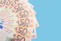 Beautifully folded euro banknotes on a blue background. Financial concept