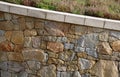 Beautifully folded retaining wall with a granite attic with small joints. brown beige yellow irregular gneiss stone holding a slop Royalty Free Stock Photo