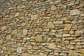 Beautifully folded retaining wall with a granite attic with small joints. brown beige yellow irregular gneiss stone holding a slop Royalty Free Stock Photo