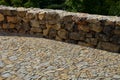 Beautifully folded retaining wall of rough stone joined with cement mortar. brown beige yellow irregular limestone stone. holding