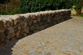 Beautifully folded retaining wall of rough stone joined with cement mortar. brown beige yellow irregular limestone stone. holding