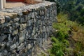 Beautifully folded retaining wall of rough stone joined with cement mortar. brown beige yellow irregular limestone stone. holding