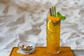 Beautifully-garnished tropical peach and orange iced tea on white sand