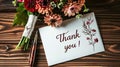 a beautifully handwritten Thank you on a white card, adorned with a bouquet of vibrant flowers and a pen, set against a