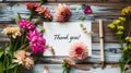 a beautifully handwritten Thank you on a white card, adorned with a bouquet of vibrant flowers and a pen, set against a