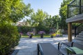 Beautifully Landscaped Backyard with Raised Gray PVC Deck and Extensive Stone Patio