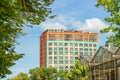 A beautifully modern building with large red green windows against a bright blue sky. Modern urban architecture, office high-rise Royalty Free Stock Photo