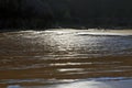 Beautifully patterened wet sand reflecting blue sky silhouetted by dark cliffs Royalty Free Stock Photo