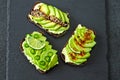 Healthy avocado toasts with spices, lime and chili, presented on a gray stone board. Royalty Free Stock Photo