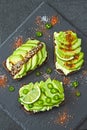 Healthy avocado toasts with spices, lime and chili, presented on a gray stone board. Royalty Free Stock Photo