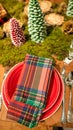Beautifully prepared table for Christmas with red dishes and tree branches Royalty Free Stock Photo